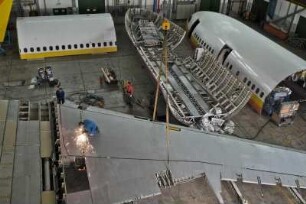 Flugzeug-Recycling am Airbus A 300. eine Tragflaeche wird abgetrennt, auf dem Boder der Halle liegen weitere grosse Teile