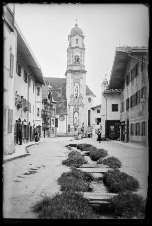 Mittenwald. Blick zur Pfarrkirche Sankt Peter und Paul mit Wasserlauf