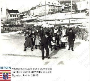 Neunkirchen im Odenwald, Teilansicht / im Vordergrund spielende Kindergruppe auf zugefrorenem Teich