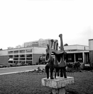Emil-von-Behring-Gymnasium: Sieker Landstraße: Kunst am Bau: vorn Grünanlage mit Bronzeplastik "Das Gespräch" des Bildhauers Ferdinand Mathiszig: dahinter parkender VW-Bus vor Schulgebäuden: links Auffahrt