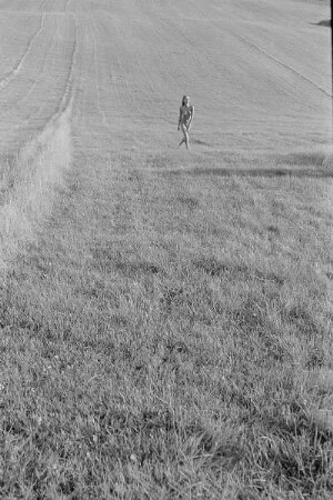 Čičmany. Akt-Pleinair 1980. Abgeerntetes Feld mit einer darüber laufenden jungen Frau
