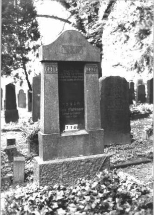Grabstein 116 (Index: 100081890) Material: Granit Zustand: gut Maße HxBxT: 211x95x33 cm Beschreibung: ädikulaart. Stele m. Pfeilern, Doppelsockel, Konvexbogenabschluß Symbolik: geflügelte Sanduhr, geometrisches Fries Steinmetz: Löffler: Grabstein 116