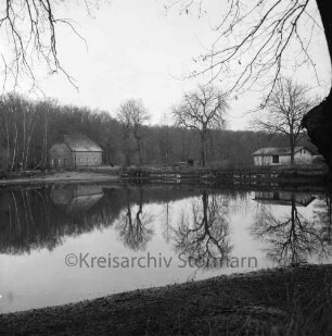 Lasbek-Gut: Lasbeker Mühlenteich: Blick nach Abriss der Lasbeker Mühle: im Hintergrund Gebäude zwischen Bäumen