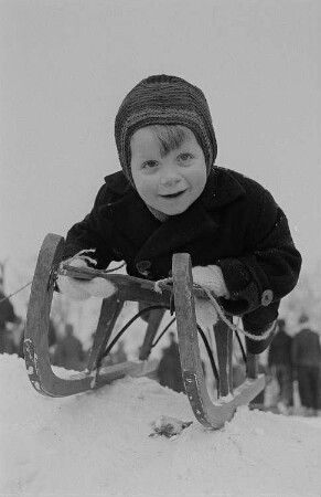 Leipzig, Johannapark. Kinder beim Ski- und Schlittenfahren, Junge liegend auf einem Schlitten