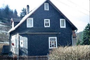 Schieferhaus; Giebelseite mit Anbau und großem Buntglasfenster