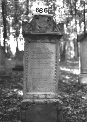 Grabstein 666 (Index: 99900567) Material: Sandstein Zustand: stellenweise verwittert Maße HxBxT: 123x45x18 cm Beschreibung: aufgesockelte Stele mit oben abgeflachtem Dreiecksaufsatz, im Dreiecksfeld Levitenkanne, daneben Eckakroterien, Schriftfeld von Zackenfries umgeben Symbolik: Levitenkanne, Zackenfries Besonderheit: Levitenkanne auf einem Frauengrab ?: Grabstein 666