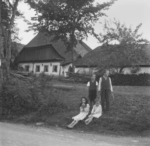 Bauernhof : Vier Kinder vor einem Gebäude eines Bauernhofs im Böhmerwald.