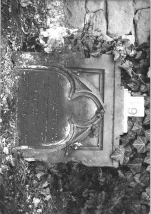 Grabstein 19 (Index: 100105960) Material: Sandstein Zustand: verwittert, unterer Teil der Stele fehlt Maße HxBxT: 58x57x15 cm Beschreibung: rechteckige Stele, Schriftfeld eingetieft mit Spitzbogenabschluß Symbolik: Maßwerk: Grabstein 19