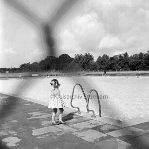 Freibad: Reeshoop: Nichtschwimmerbecken: in der Mitte neben Treppengeländer Mädchen am Beckenrand: im Hintergrund Wiese und Bäume