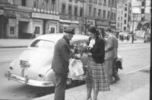 Berlin. Frau kauft von einem Straßenverkäufer einen Blumenstrauß (Serie "Berliner Schnappschüsse")
