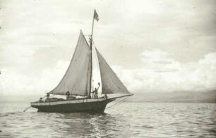 Reisefotos. Segelschiff mit winkendem Besatzungsmitglied. Ansicht von einem Passagierschiff (vielleicht in der Karibik)