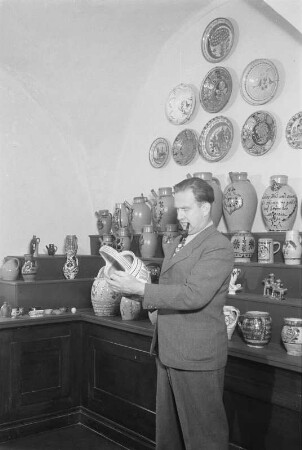 Dresden, Köpckestraße 1: Museum für Sächsische Volkskunst mit Puppentheatersammlung (1927-1949 Oskar-Seyffert-Museum), Ausstellung Erdgeschoßhalle nach Rücktransport der ab 1942 in Schloss Weesenstein eingelagerten Bestände. Direktor Reinhold Langner vor Nische mit bäuerlicher Keramik