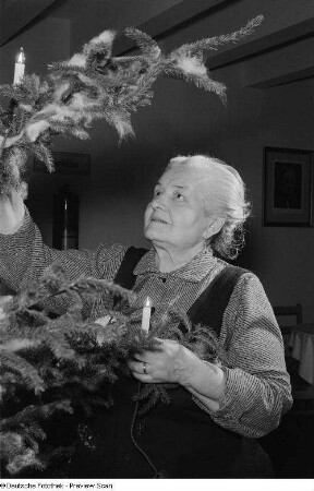 Porträt einer alten Frau an einem Weihnachtsbaum