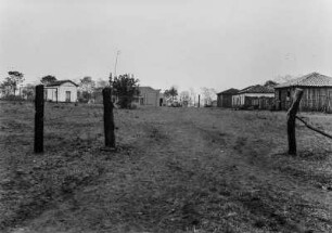 Häuser von Santo Antônio do Aracanguá : Blick auf Häuser von Santo Antônio do Arancanguá und einen Platz. Im Vordergrund ein Zaun mit Stacheldraht.