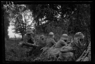 Bei Metz-en-Couture (Dep. Pas-de-Calais, Frankreich): "Sturmtrupp" am Waldrand in Deckung, ein Soldat beim Werfen einer Stilgranate (Seitansicht, Nahaufnahme)