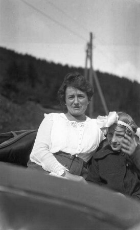 Portrait einer Frau und eines jungen Mädchens, auf dem Rücksitz eines Personenkraftwagens sitzend