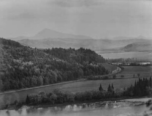Landschaft : Blick über eine Landschaft mit bewaldeten Hängen und Fluss im Vordergrund. Im Hintergrund Berge