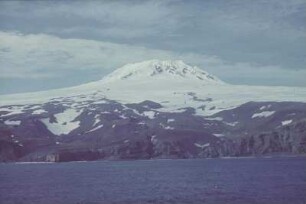 Reisefotos Norwegen. Felsige Küste mit schneebedecktem Massiv