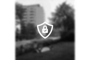 Kurparkallee: vorn umgelegte Bank im Kurpark: dahinter parkende Pkws: hinten links Hochhaus "Liebe"