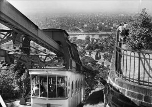Schwebeseilbahn Loschwitz - Oberloschwitz : Dresden-Loschwitz. Schwebeseilbahn Loschwitz - Oberloschwitz (1898-1901; Elektra-AG Dresden). Traggerüst mit Fahrbalken und Teilansicht eines Seilbahnwagens mit zwei Tragbügeln. Blick hangabwärts auf Elbtal und Blasewitz