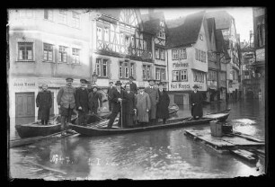 Hochwasser in der Brückengasse vor dem Cafe Quenzer, Geschäft Jakob Beysel und Möbellager Karl Kappes, darauf Personen auf Schelchen und Stegen, darauf Nr. 47