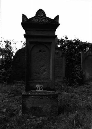 Grabstein 69 (Index: 99891717) Material: Sandstein Zustand: Inschrifttafel zerstört Maße HxBxT: 166x52x27 cm Beschreibung: rechteckige Stele auf Sockel, Mittelakroter und Eckakrotere Symbolik: Palmette in Mittelakroter, halbe Palmette in Eckakroter: Grabstein 69
