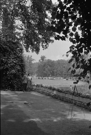 Markkleeberg, Agra-Park (ehemaliger Herfurthscher Park). Pärchen auf einem Parkweg vor Stativ und Fotoapparat mit Selbstauslöser