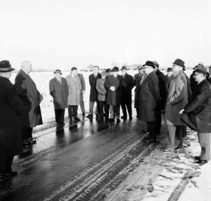 Straßenbau: Kreisstraße Richtung Wakendorf (Kreis Segeberg): Einweihung und Freigabe: Begehung der Straße durch Landrat Wennemar Haarmann, Bürgermeister Adolf Grimm, Kreisverkehrsausschussmitglieder, Gemeindevertreter sowie Vertreter des Kreises Segeberg und der Gemeinde Wakendorf: hinten Bäume: Winter