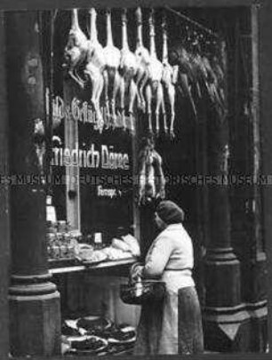 Frau vor einem Schaufenster mit Lebensmitteln