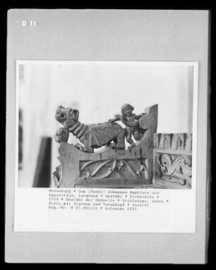 Gestühl der Südseite — Stuhlwange, innen — Putto mit Drachen und Totenkopf