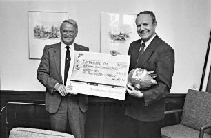 Scheckübergabe von Helmuth Rieken, Vorsitzender des Vereins für Leibesübungen (VfL) Tremsbüttel, an Kreispräsident Hubert Priemel für den United Nations International Children's Emergency Fund (UNICEF) über 1000 DM im Stormarnhaus