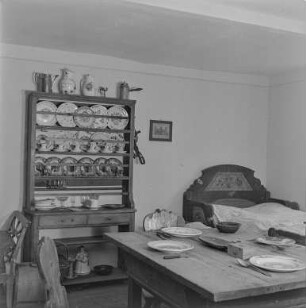 Rat des Kreises : Oberlausitz. Unbekannter Ort, Museum. Bauernstube mit gedecktem Tisch, Bett und einem Tellerregal