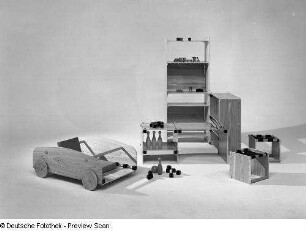 Kinderzimmermöbe : Leipziger Herbstmesse, 1972. Kinderzimmermöbel (1972; Hochschule für Kunst und Design Halle (Burg Giebichenstein)). Ansicht mit Regal, Hockern und Spielzeugkiste in Autoform mit Rädern