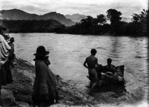 Übersetzen über den Rio Mizque : Personen an einem Flussufer. Eine Gruppe von Männern mit einem Kleinen Boot im Wasser
