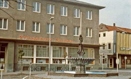 Kreissparkasse Stormarn am Markplatz, im Vordergrund Gänseliesel-Brunnen, im Hintergrund Thalia Kino