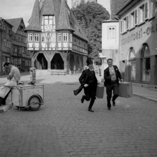 Michelstadt (Odenwaldkreis). Marktplatz. Filmaufnahmen. Szene mit zwei rennenden Herren mit Koffern. Blick gegen Rathaus