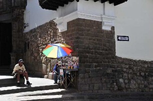 Cusco - Sonnenschirm vor einer Mauer aus der Inka-Zeit : Vor einer Mauer aus der Inka-Zeit bietet ein Mann unter einem Sonnenschirm Getränke an. Aufgenommen am 30. August 2011 in der einstigen Inka-Hauptstadt Cusco