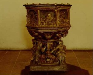 Taufstein mit Reliefszenen (Sintflut, Zug durch das Rote Meer, Taufe Christi, Christus als Kinderfreund) zwischen den Evangelisten