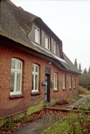 Sandweg 3: Fachwerkhaus mit Reetdach: traufständige Straßenfront mit Eingangstür und breiter Gaube