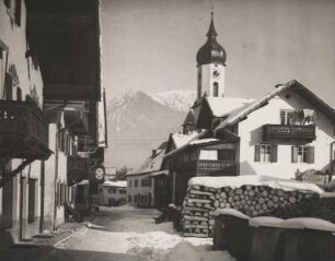 Oberbayern. Garmisch. Winter. Verschneite Sonnenstraße gegen den Wank. In der Bildmitte die Kirche St. Martin