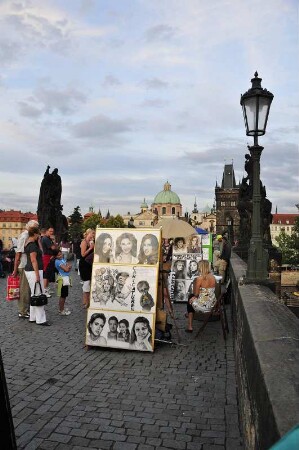 Karlsbrücke : Touristen sehen auf der Prager Karlsbrücke einem Porträtmaler bei der Arbeit zu