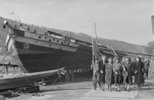 Mitglieder der FDJ während einer Osterfahrt nach Bad Schandau : Wandergruppe an einem Schiff am Ufer der Elbe