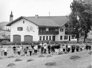 Das Jugenderholungsheim der Deutschen Angestellten Krankenkasse (DAK) in Wertach/Oberallgäu. Jugendliche laufen über ein Feld.