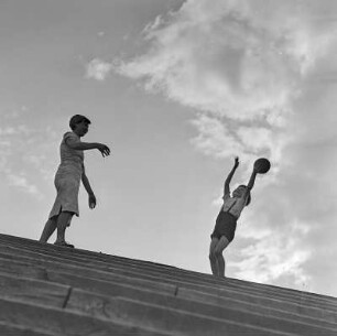 Elisabeth Gremmler und ihr Kind spielen Ball auf einer Treppe