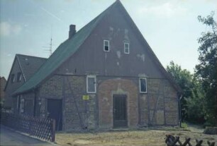 Benstaben 1: traufständiges Fachwerkhaus: Giebelseite Wirtschaftstrakt: Giebel mit Verbretterung: Scheunentor mit Vermauerung, darin Tür: nach Modernisierung der Fenster