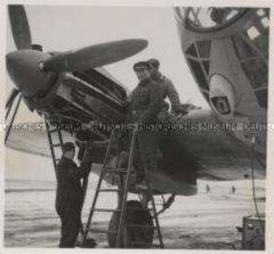 Wehrmachtssoldaten, Flugzeug, Motorüberholung auf winterlichem Flugplatz im Osten (Heinkel He 111)