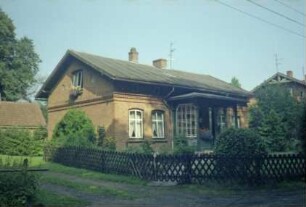 Altfresenburg 12: traufständiges Wohnhaus mit Eingangsveranda: Straßenfront, Giebelseite