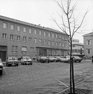 Kreissparkasse Stormarn: Markt: Altbau, mit Firmenname: hinten Neubau Kreissparkassenzentrale in Hagenstraße: hinten rechts Historisches Rathaus, Gänseliesel-Brunnen: Markt mit Kopfsteinpflaster, Parkplätze, Parkuhren, parkende Autos, Straßenlampen: im Vordergrund junger Baum
