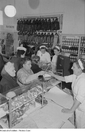 Verkäuferinnen bedienen Kunden einer Fleisch- und Wursttheke