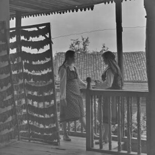 Veranda eines Wohnhauses in Bansko. Frauen in bulgarischer Tracht